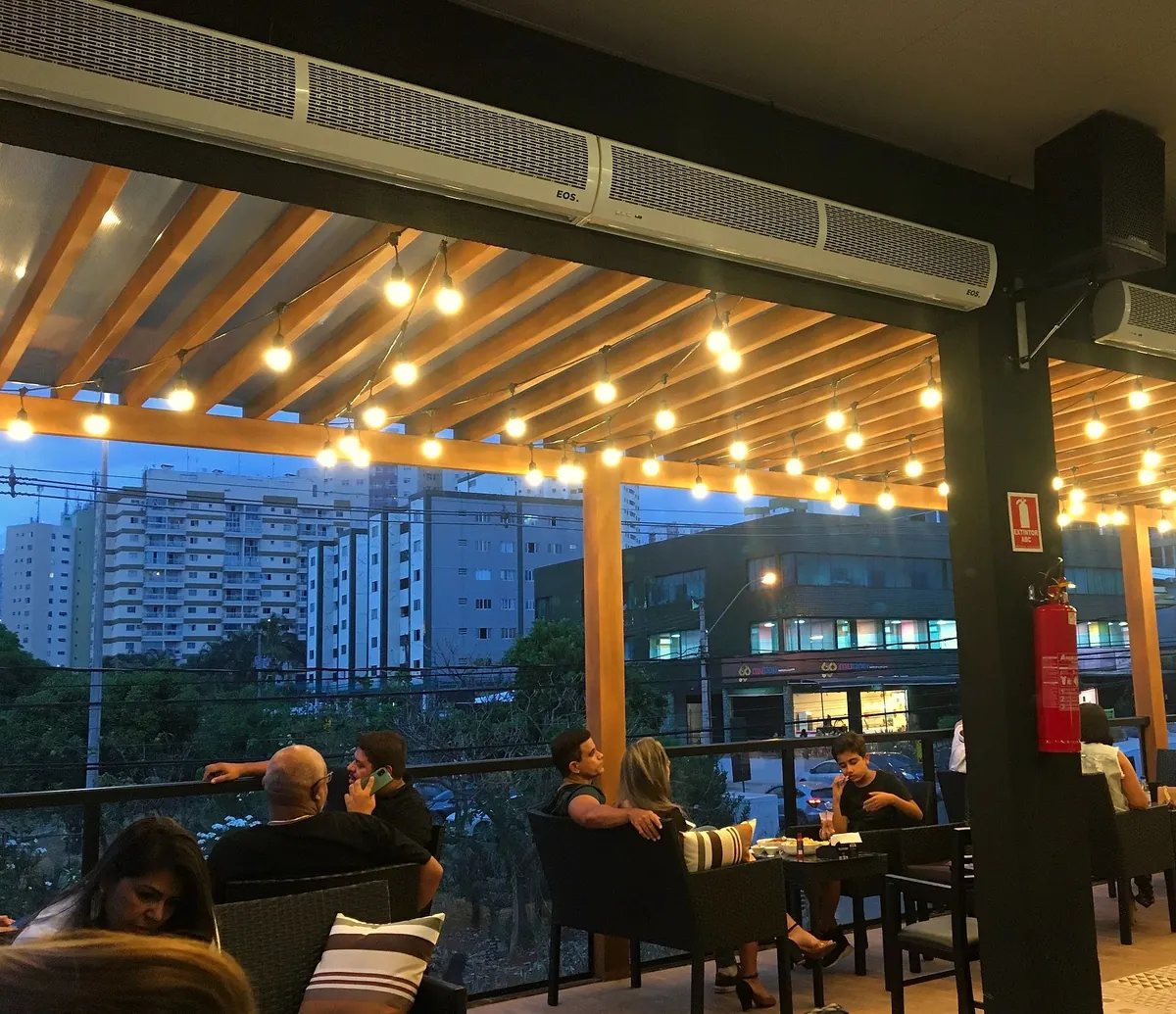 Terraço do VBQ ao entardecer, com luzes acesas e vista para Águas Claras